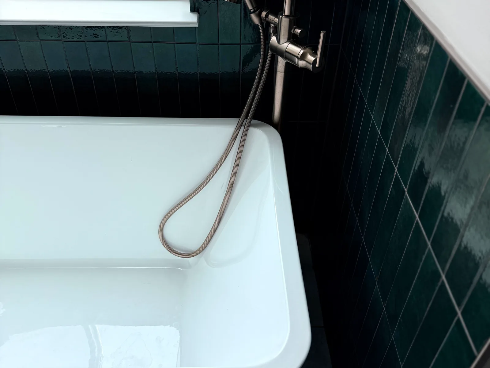 Freestanding bathtub with a floor mounted tub filler, plumbing work