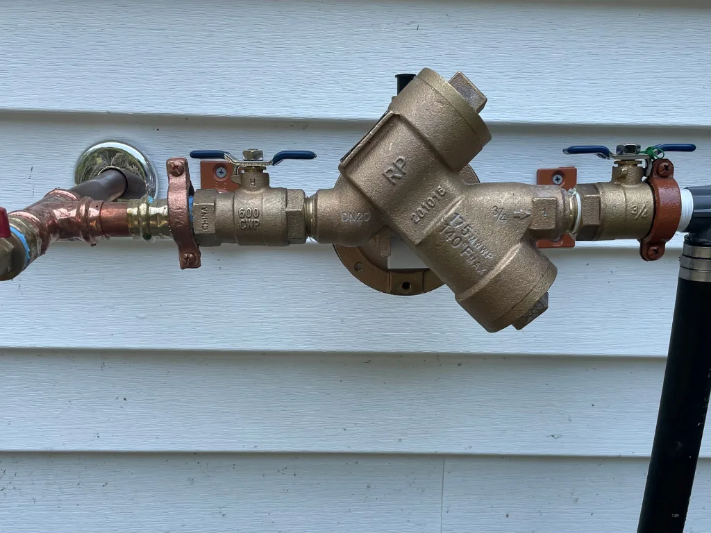 Brass reduced pressure backflow preventer on a house wall, backflow prevention