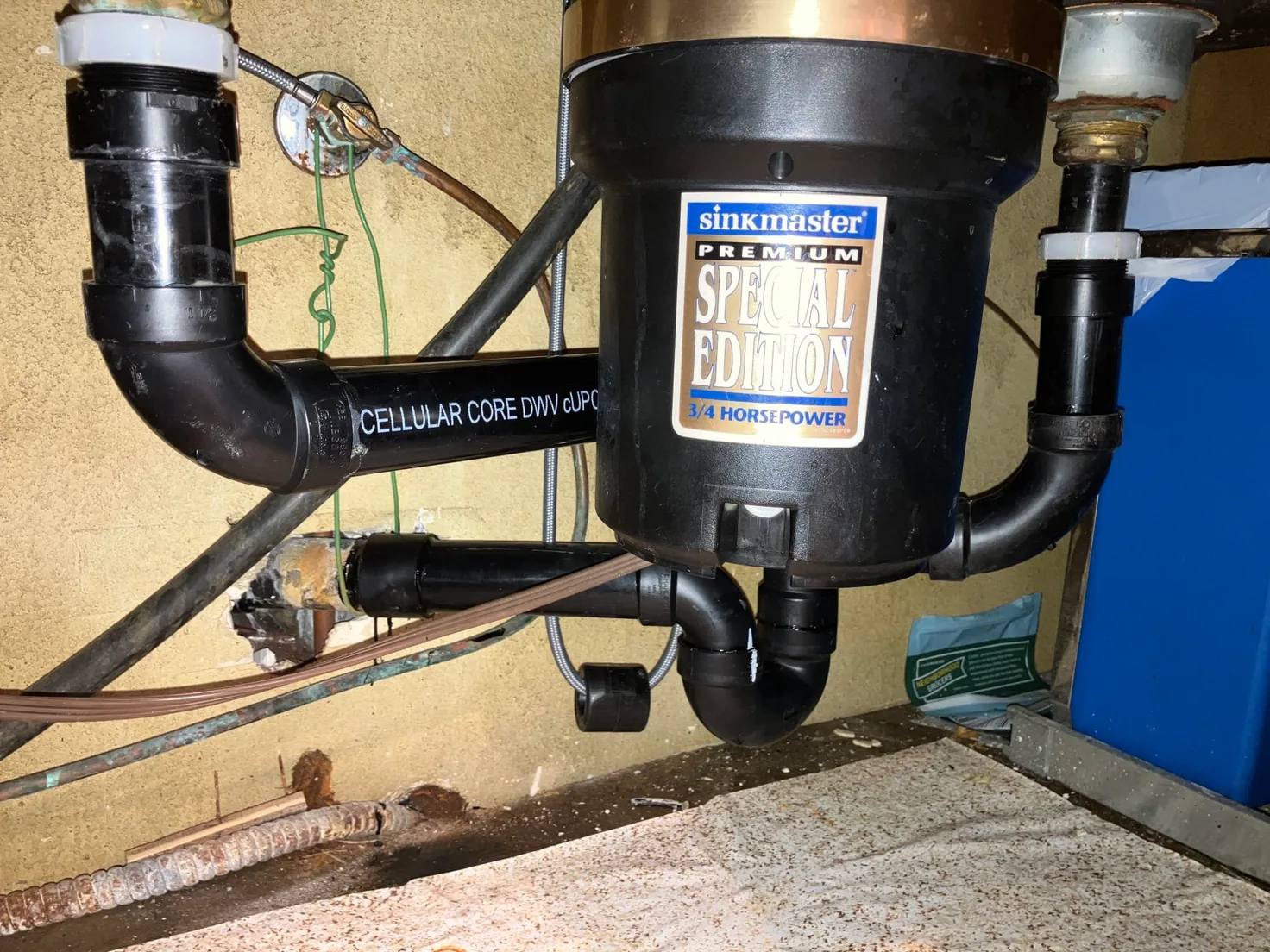 Garbage disposal connected to new drain piping under a sink, garbage disposal repair