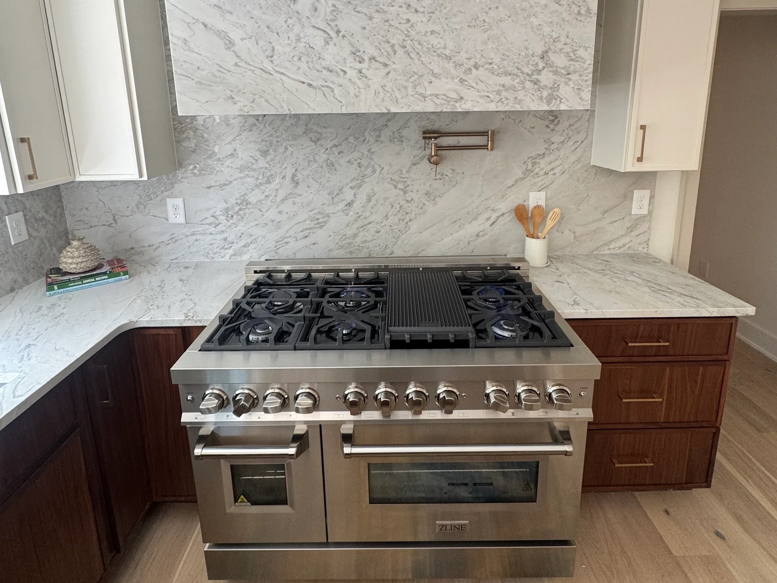 Gas range with lit burners under a vent hood in a kitchen, gas line installation