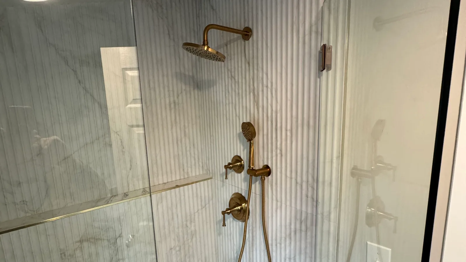 Glass shower with brass shower fixtures, plumbing services