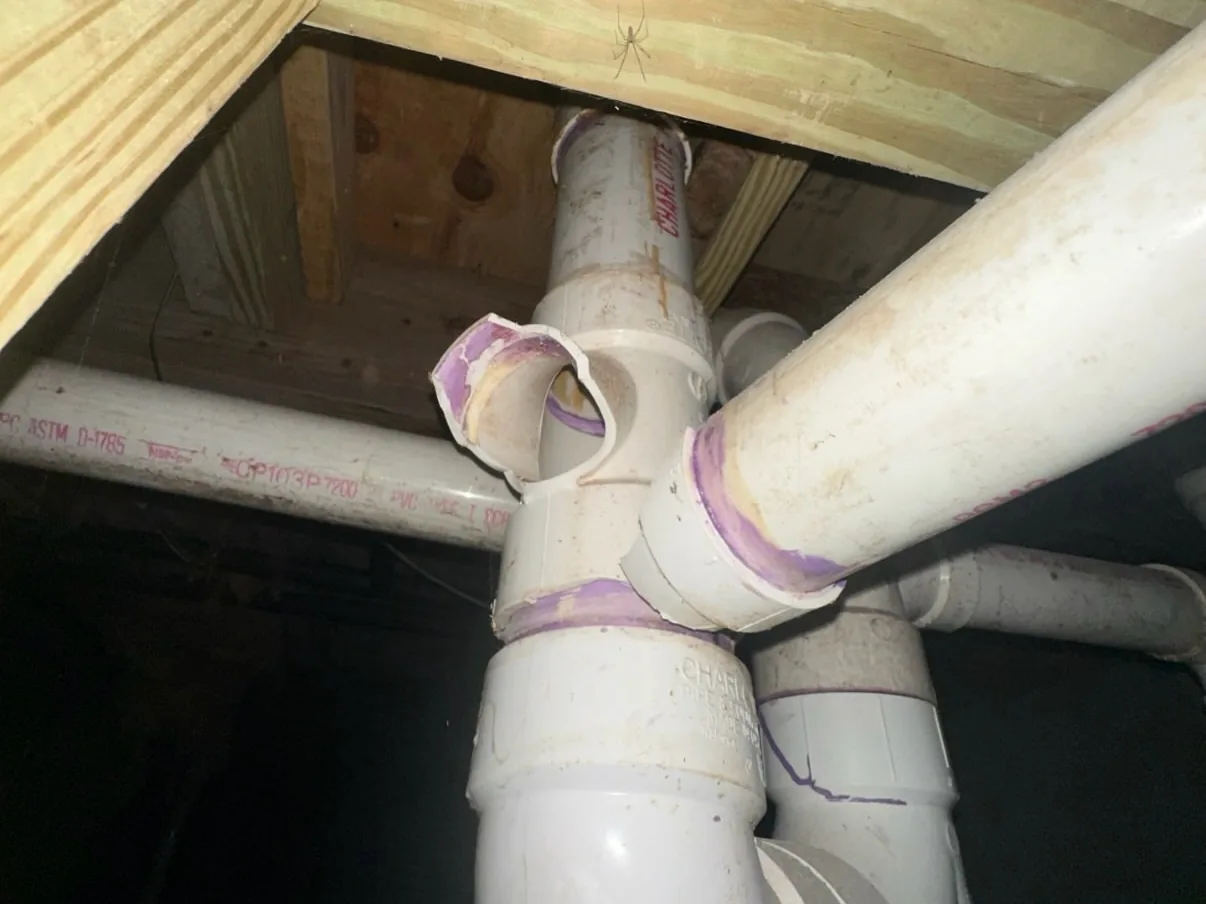 Broken PVC drain fitting under a house, sewer line repair