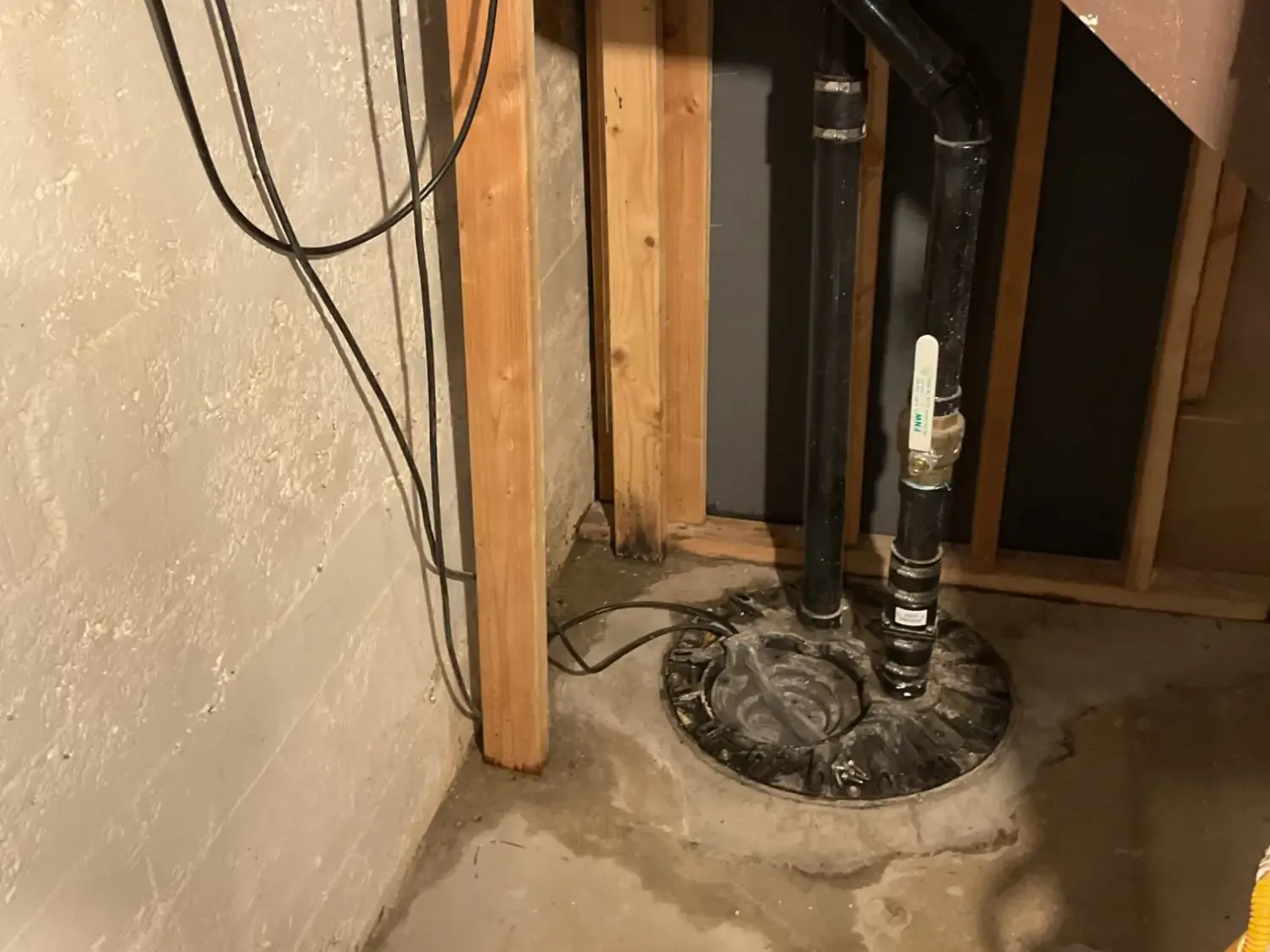 Sealed sump pit lid with a discharge pipe and valve in a basement, sump pump installation