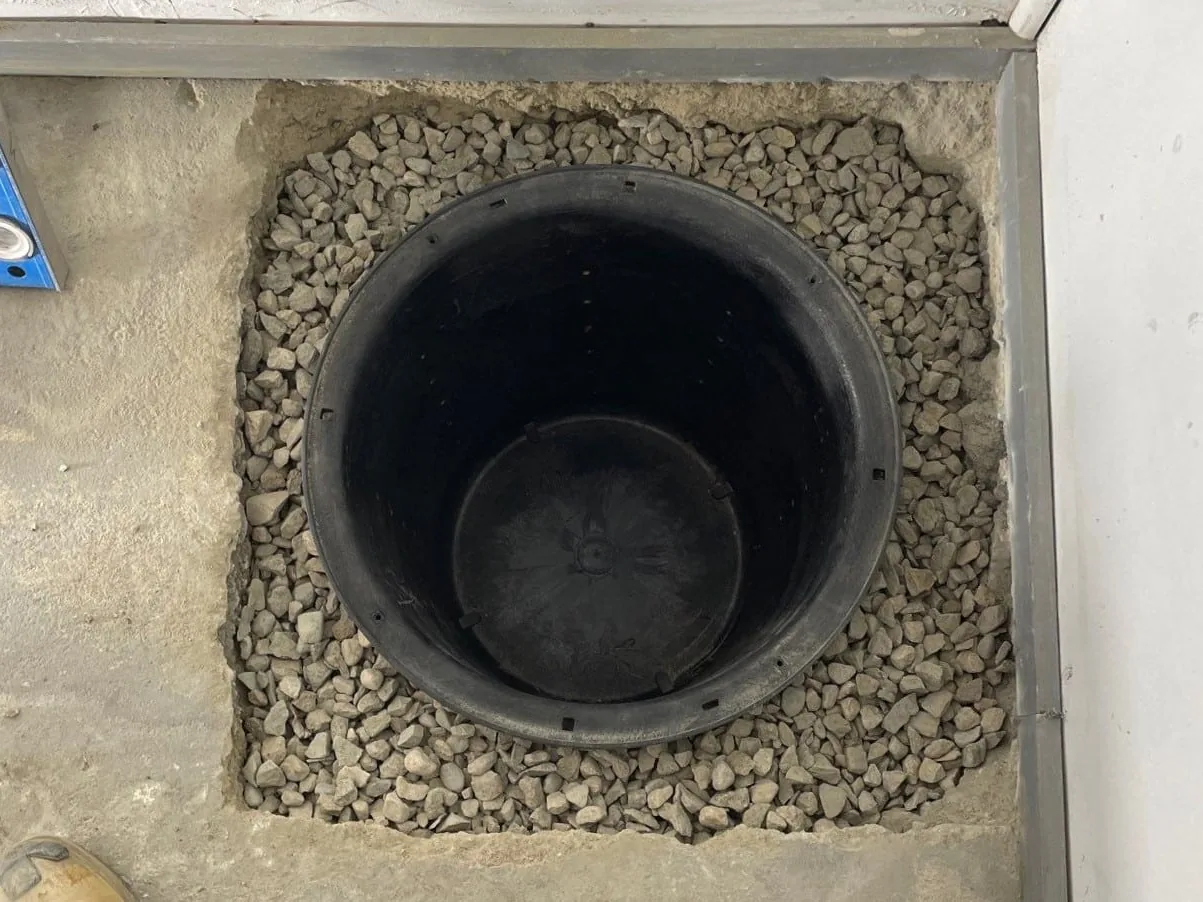 New sump basin set in gravel in a basement floor, sump pump installation