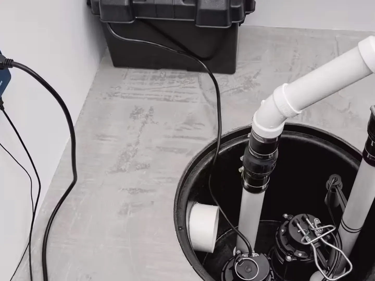 Sump pit with two pumps, discharge pipes and a backup battery box, sump pump installation
