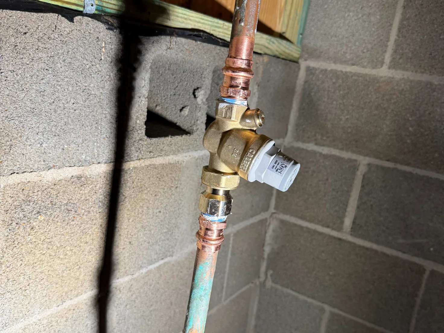 New pressure regulating valve on a copper water line by a block wall, water line repair