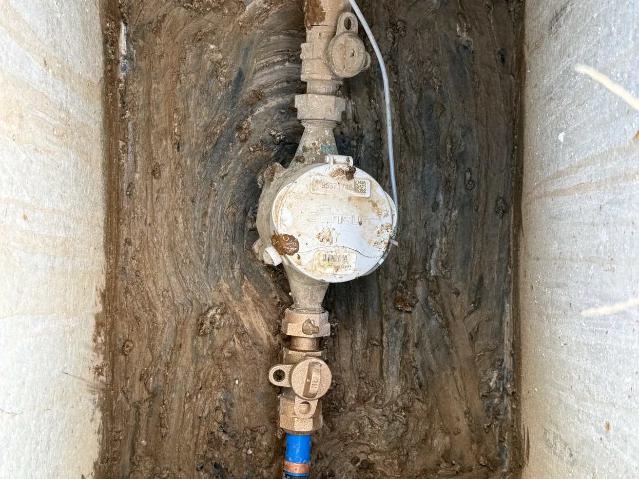 Water meter with a new blue service line in a meter box, water line repair